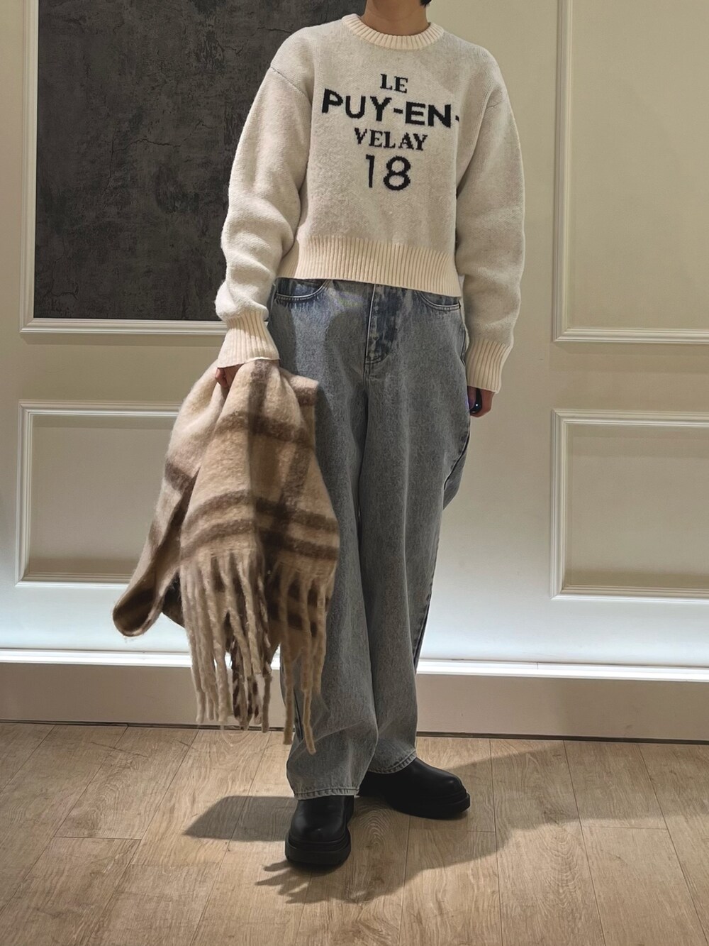 ブルー系のデニムパンツ、ホワイト系のニット/セーター、グレー系のブルゾンを着用したレディースの冬コーディネートの3枚目の写真