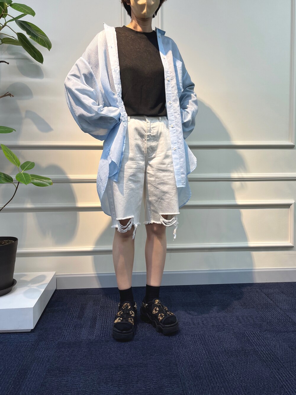 ホワイト系のデニムパンツ、イエロー系のシャツ/ブラウス、ブラック系のサンダルを着用したレディースの春コーディネートの2枚目の写真