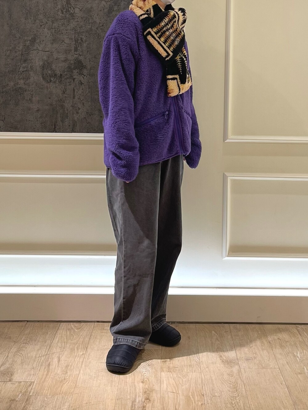 グレー系のデニムパンツ、ブラック系のサンダル、パープル系のカーディガン/ボレロを着用したレディースの秋コーディネートの3枚目の写真