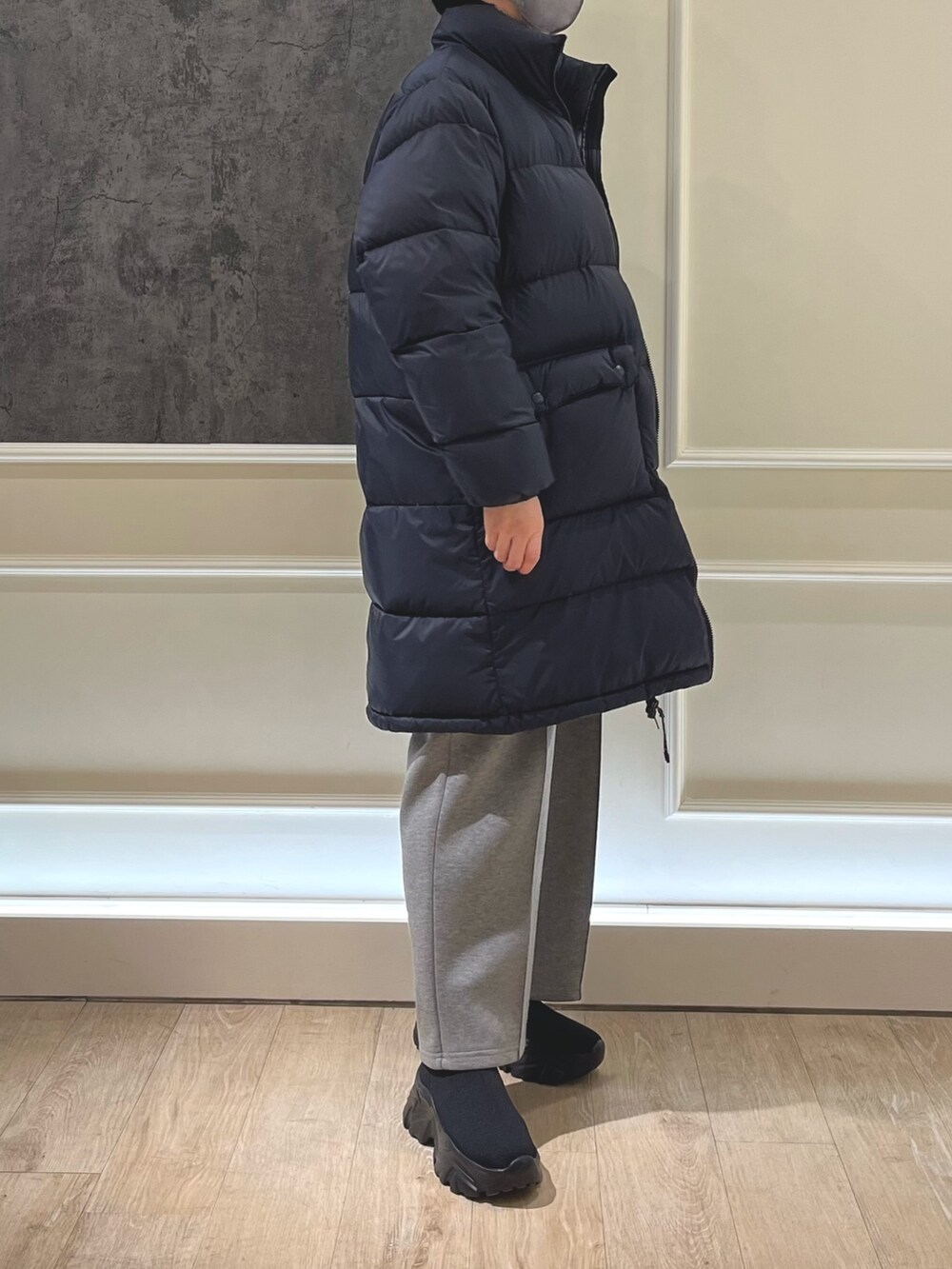 ブラック系のダウンジャケット/コート、グレー系のニット/セーター、グレー系のその他パンツを着用したレディースの冬コーディネートの2枚目の写真