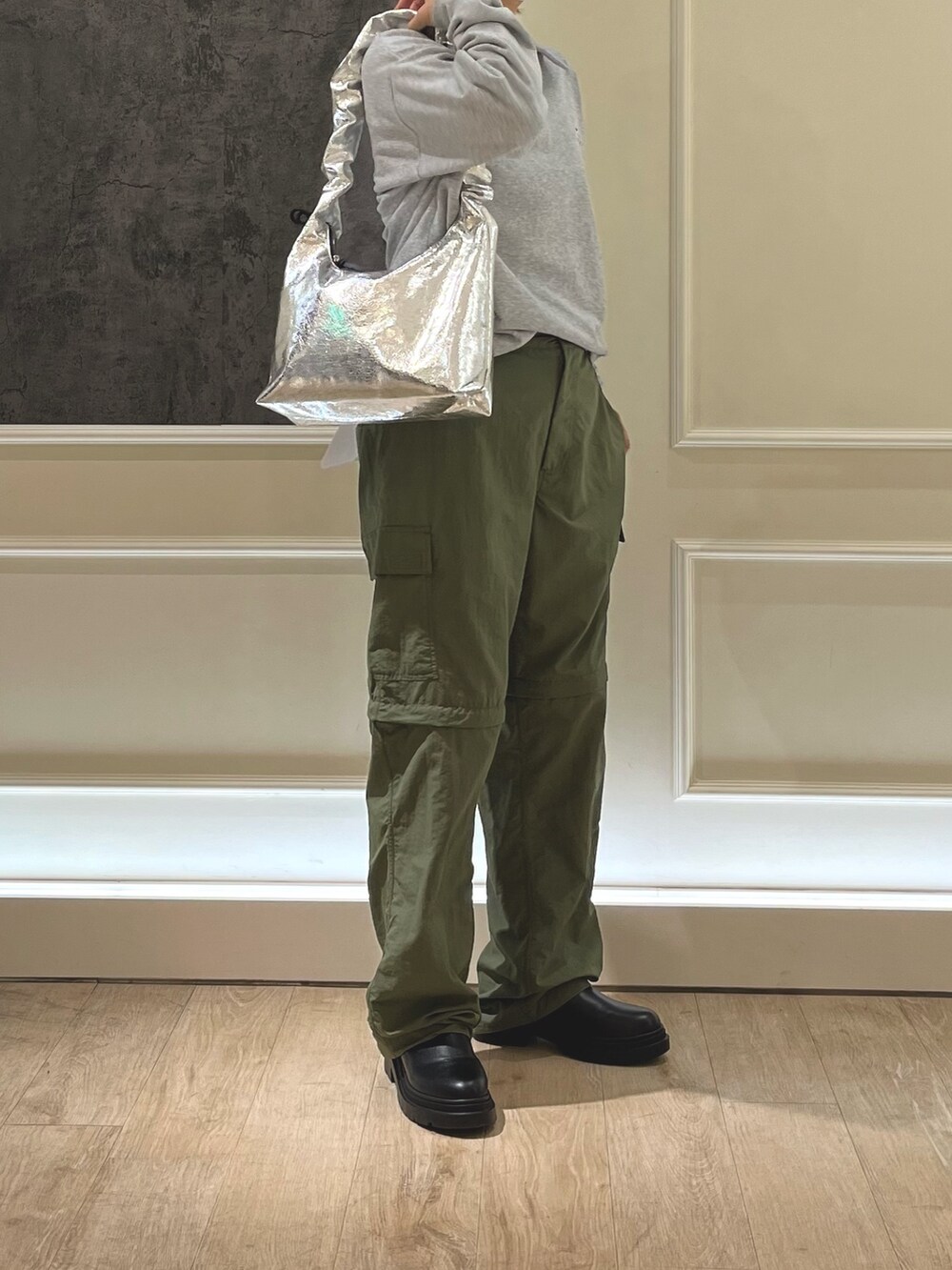 グレー系のポロシャツ、シルバー系のショルダーバッグを着用したレディースの冬コーディネートの2枚目の写真