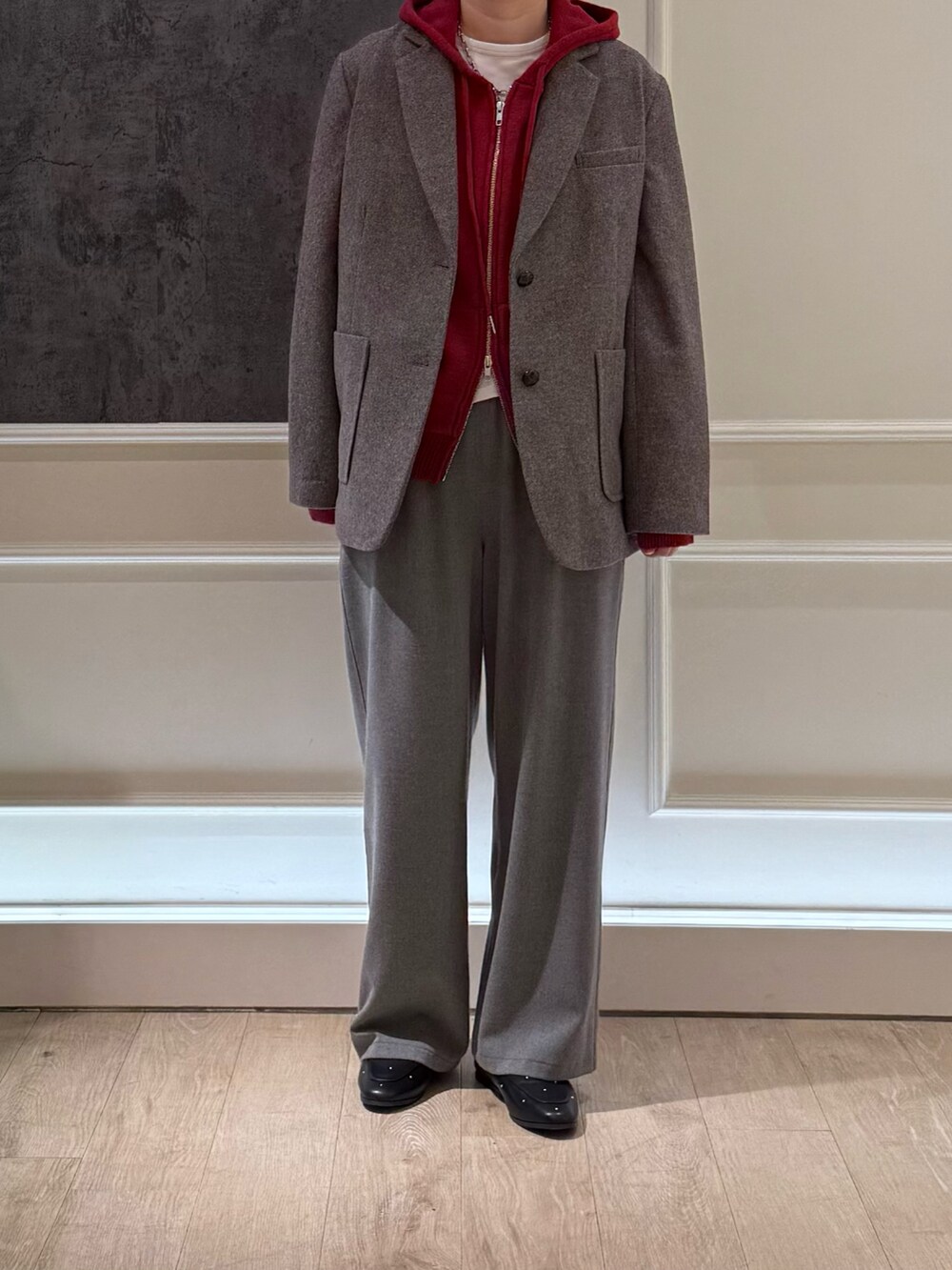 ブラウン系のテーラードジャケット、グレー系のその他パンツ、レッド系のパーカーを着用したレディースの冬コーディネートの3枚目の写真
