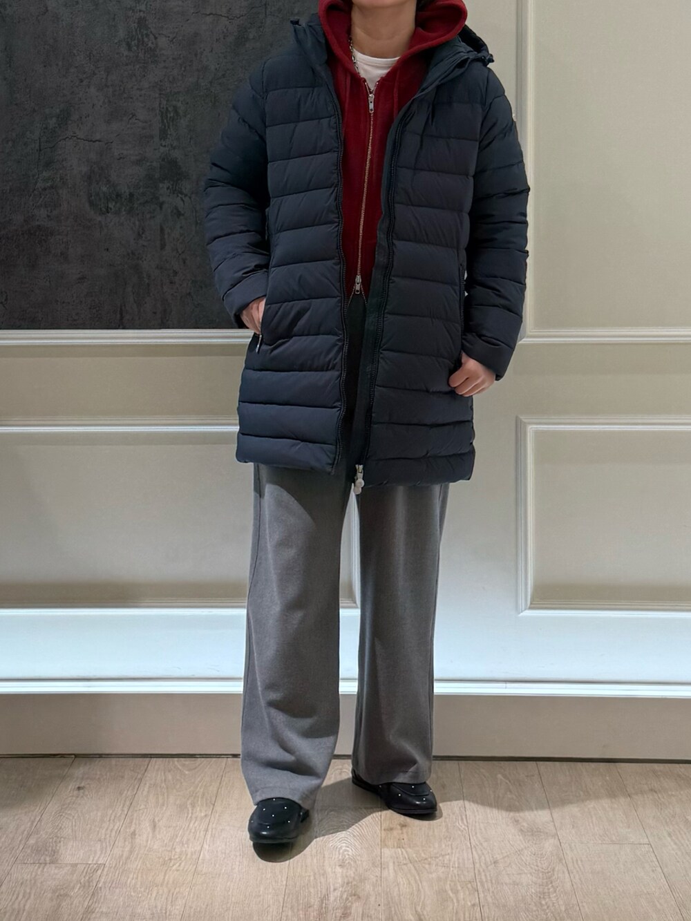 グレー系のダウンジャケット/コート、レッド系のパーカー、グレー系のその他パンツを着用したレディースの秋コーディネートの3枚目の写真