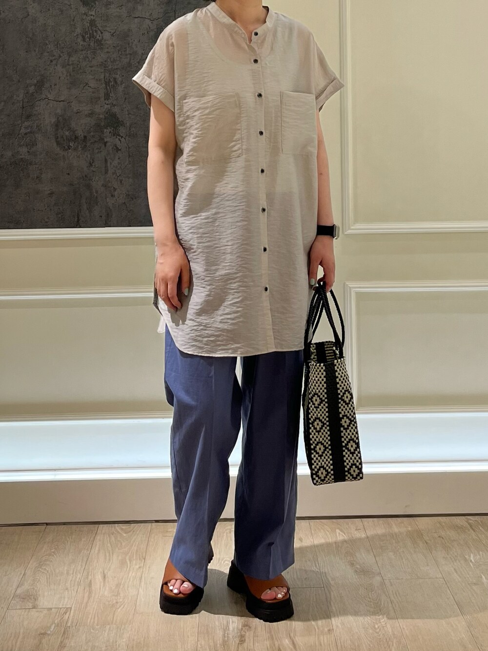 ベージュ系のシャツ/ブラウス、ブラック系のスラックス、ブラウン系のサンダルを着用したレディースの夏コーディネートの2枚目の写真