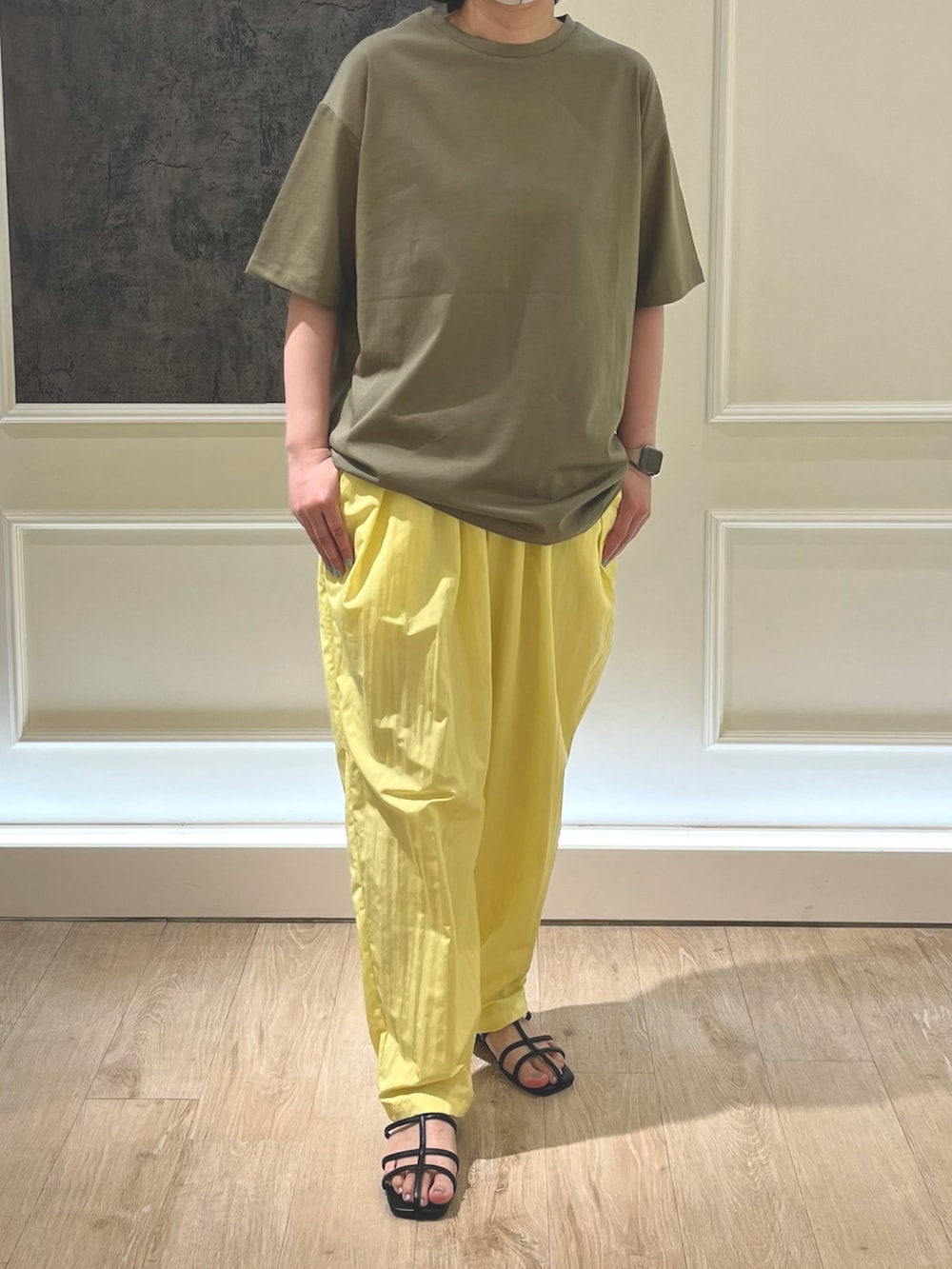 グリーン系のTシャツ/カットソー、ブラック系のサンダル、イエロー系のその他パンツを着用したレディースの春コーディネートの2枚目の写真