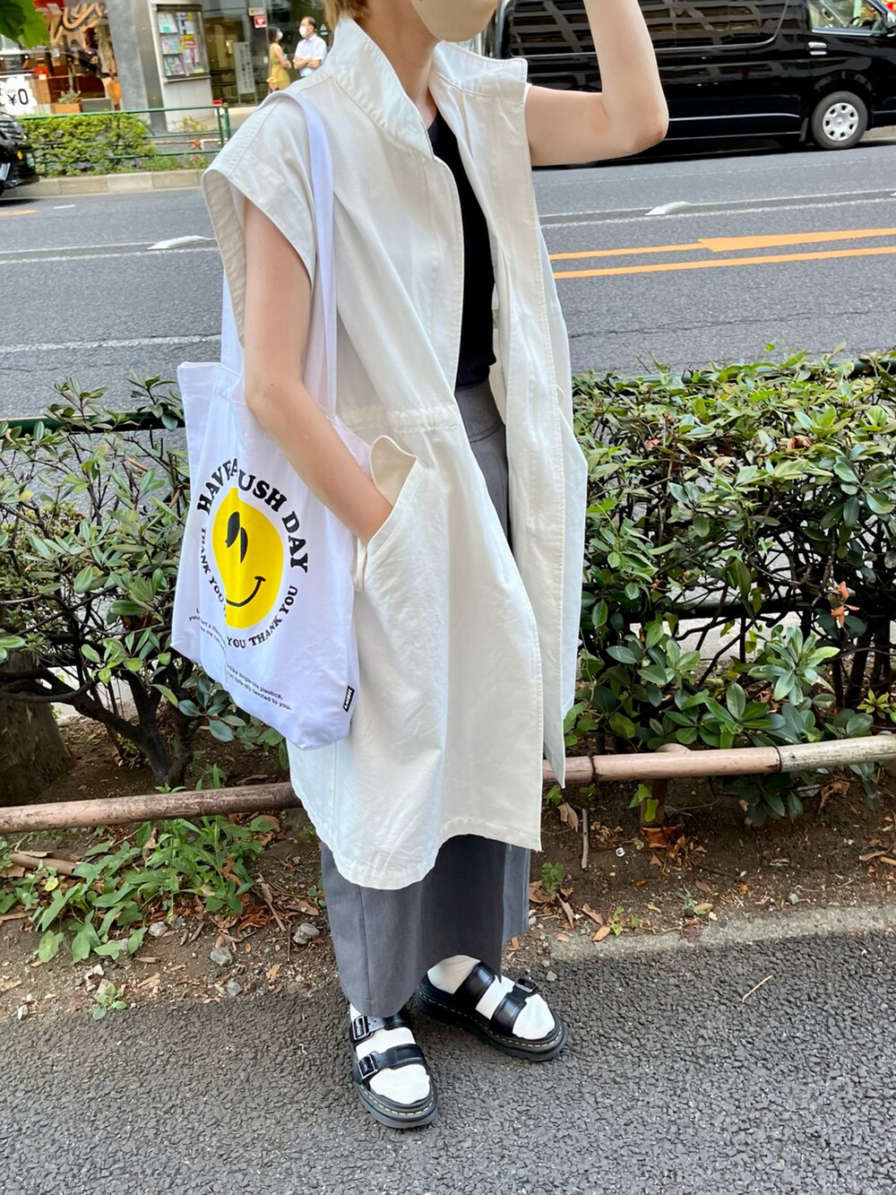 ホワイト系のベスト、ブラック系のサンダル、グレー系のスカートを着用したレディースの夏コーディネートの3枚目の写真