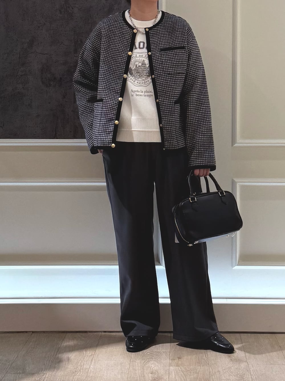 ブラック系のブルゾン、ホワイト系のニット/セーター、グレー系のその他パンツを着用したレディースの冬コーディネートの3枚目の写真