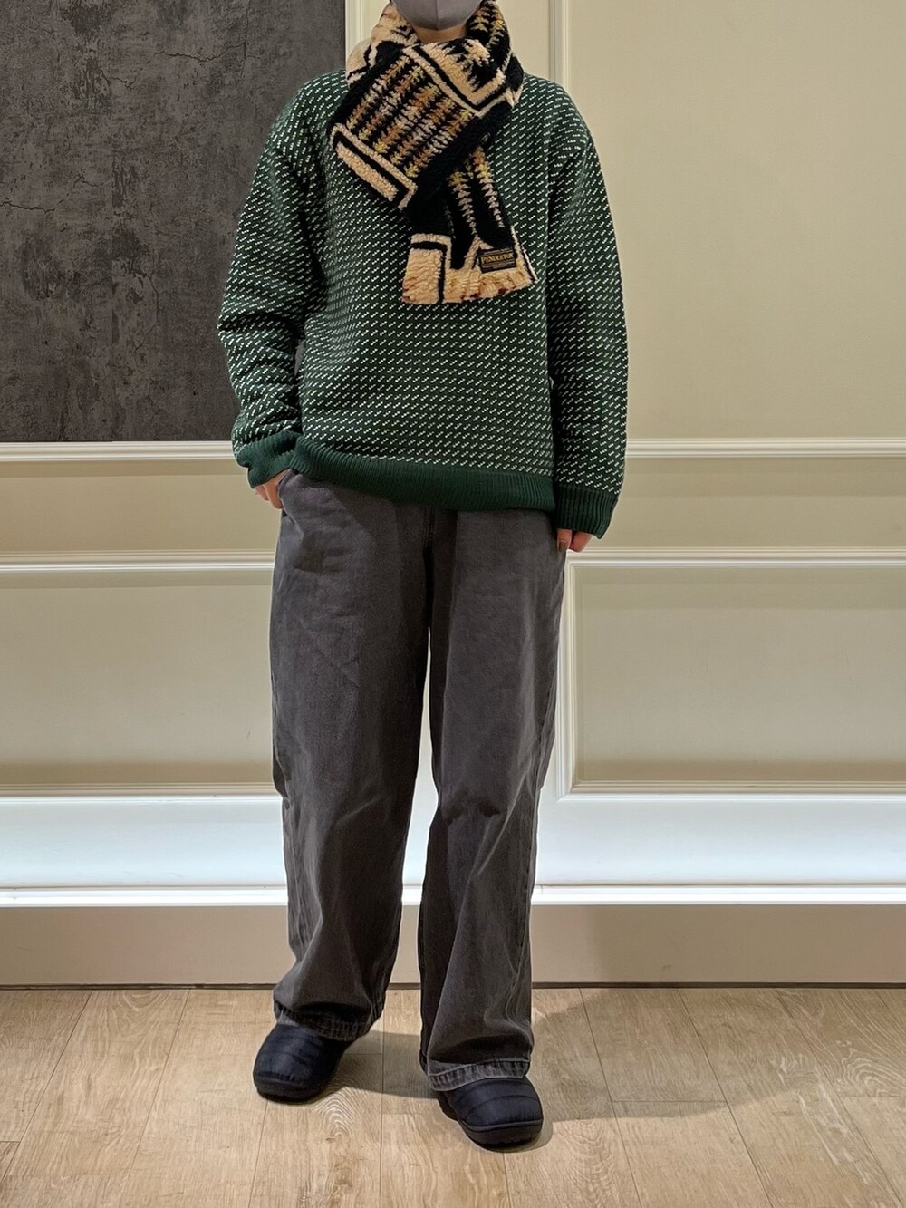 グリーン系のニット/セーター、グレー系のデニムパンツ、ブラック系のサンダルを着用したレディースの冬コーディネートの2枚目の写真