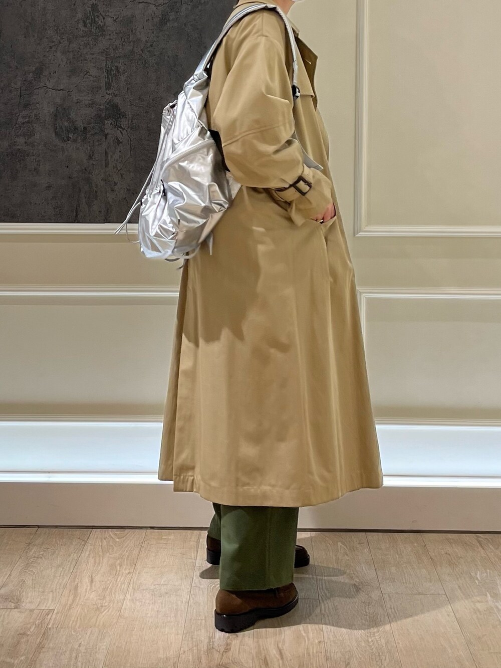 ベージュ系のトレンチコート、ブルー系のスウェット、シルバー系のバックパック/リュックを着用したレディースの冬コーディネートの2枚目の写真