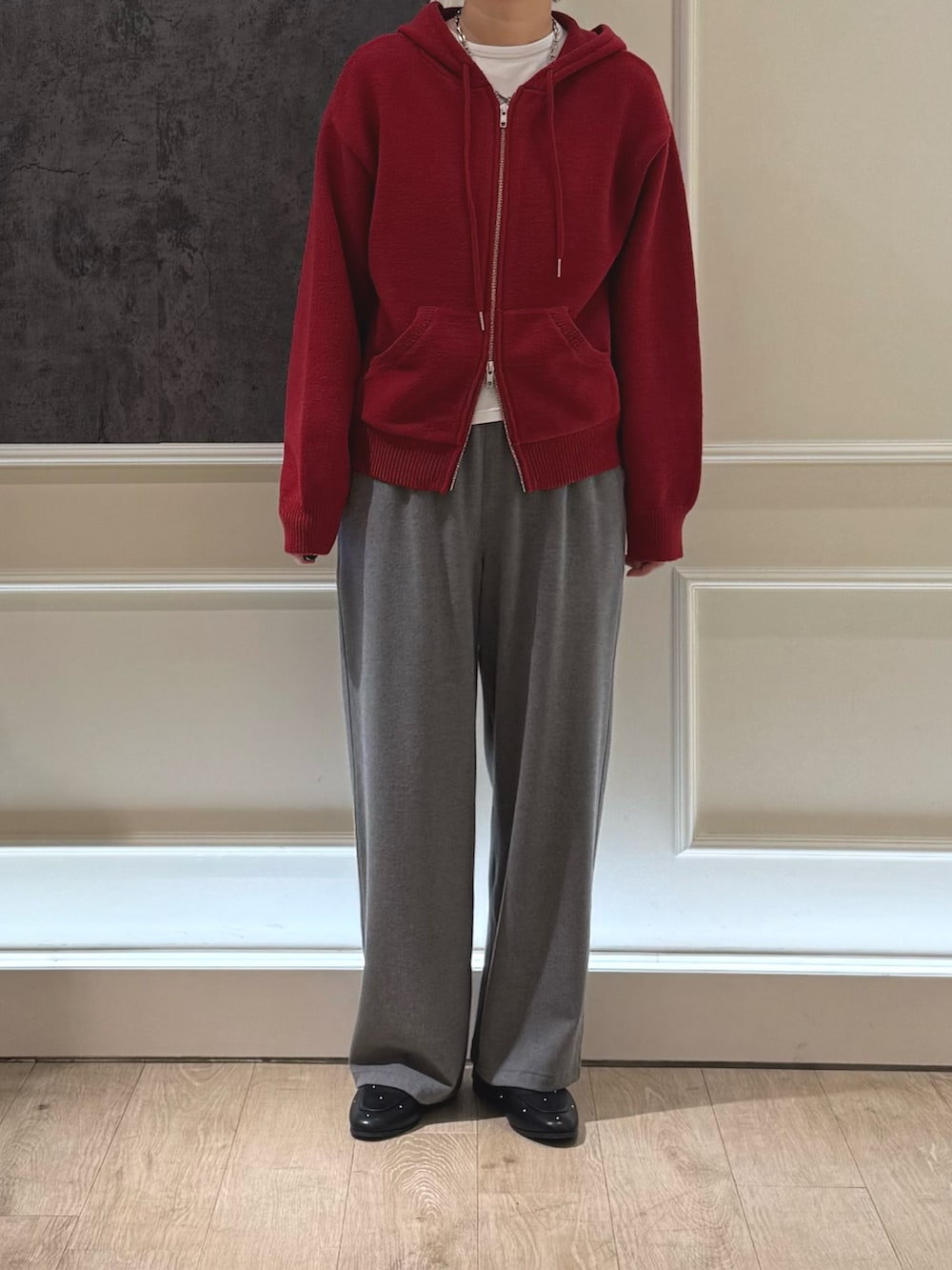 レッド系のパーカー、グレー系のその他パンツ、ブラック系のパンプスを着用したレディースの冬コーディネートの2枚目の写真