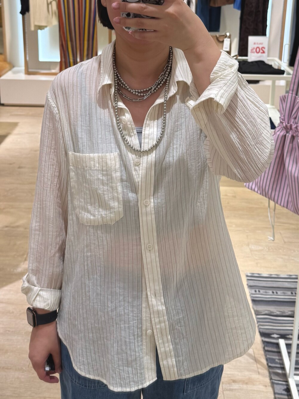 ブルー系のデニムパンツ、ベージュ系のサンダル、ホワイト系のシャツ/ブラウスを着用したレディースの夏コーディネートの2枚目の写真