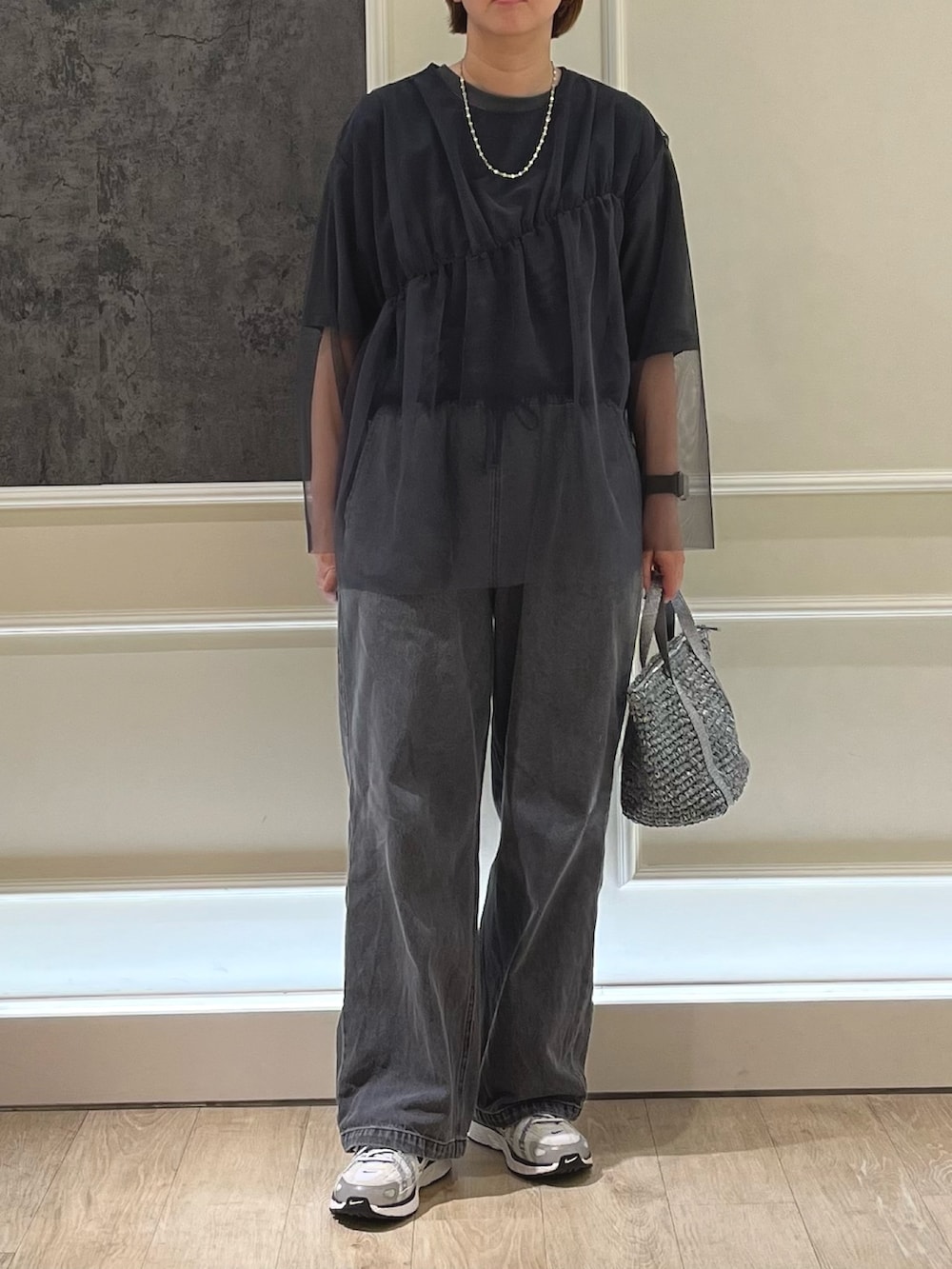 グレー系のシャツ/ブラウス、ブラック系のデニムパンツ、グレー系のトートバッグを着用したレディースの春コーディネートの2枚目の写真