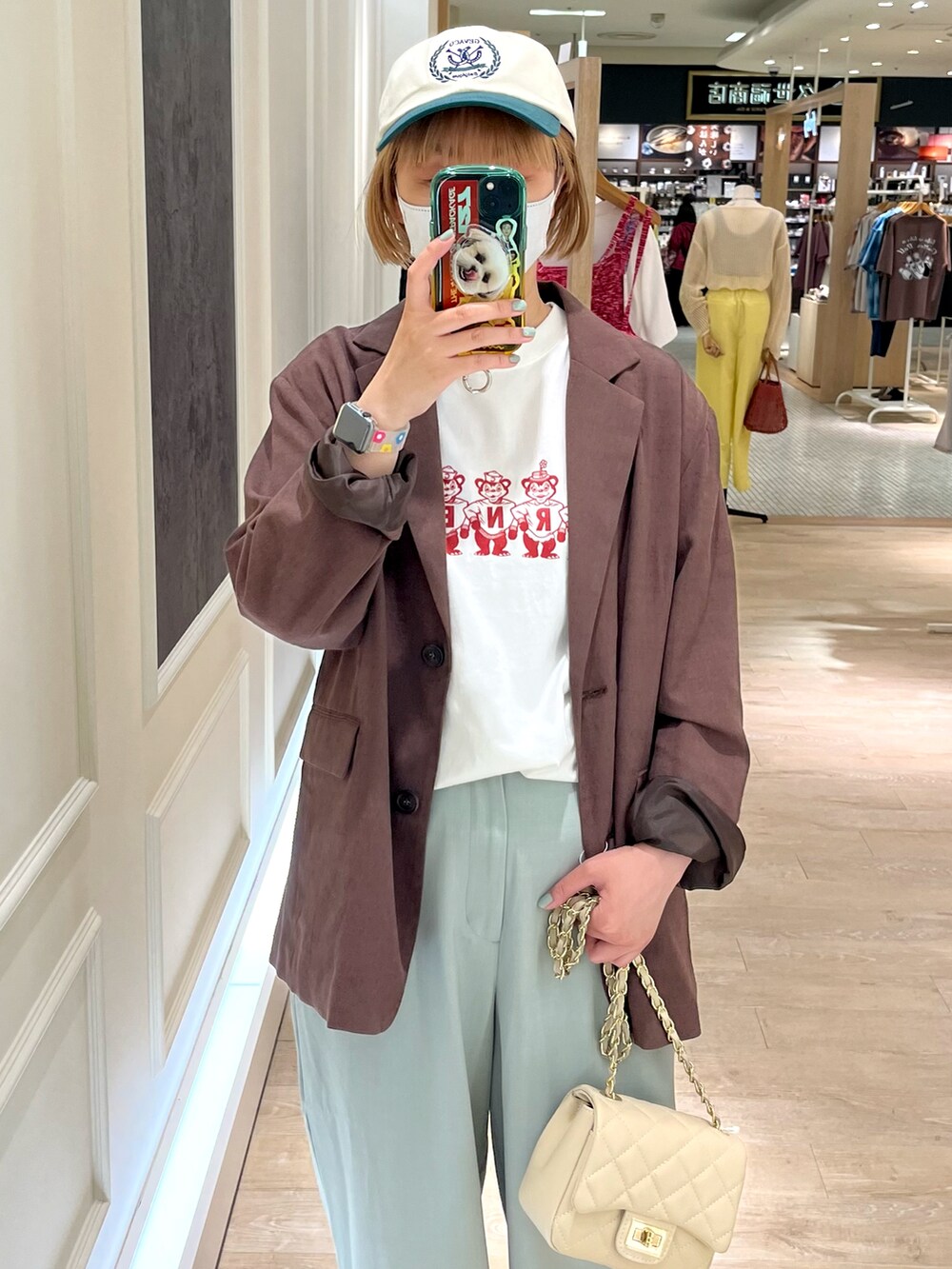 グリーン系のスラックス、ブラウン系のテーラードジャケット、ホワイト系のTシャツ/カットソーを着用したレディースの春コーディネートの3枚目の写真