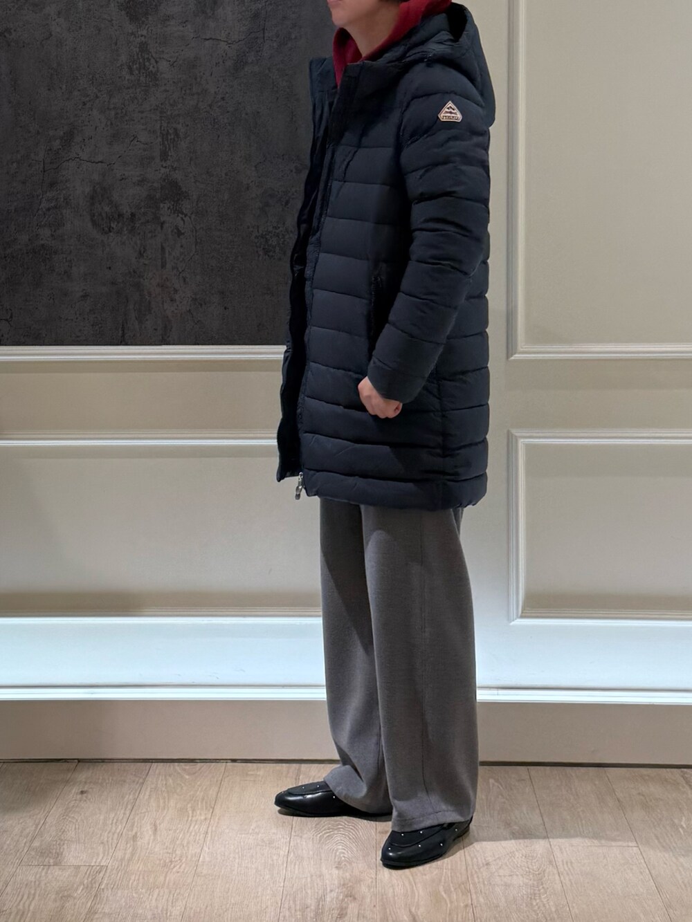 グレー系のダウンジャケット/コート、レッド系のパーカー、グレー系のその他パンツを着用したレディースの秋コーディネートの4枚目の写真