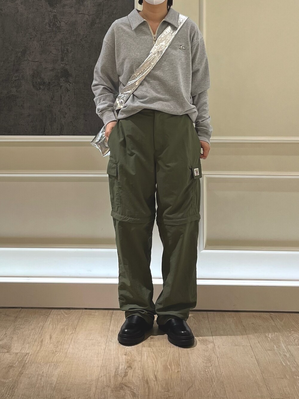 グレー系のポロシャツ、シルバー系のショルダーバッグを着用したレディースの冬コーディネートの3枚目の写真