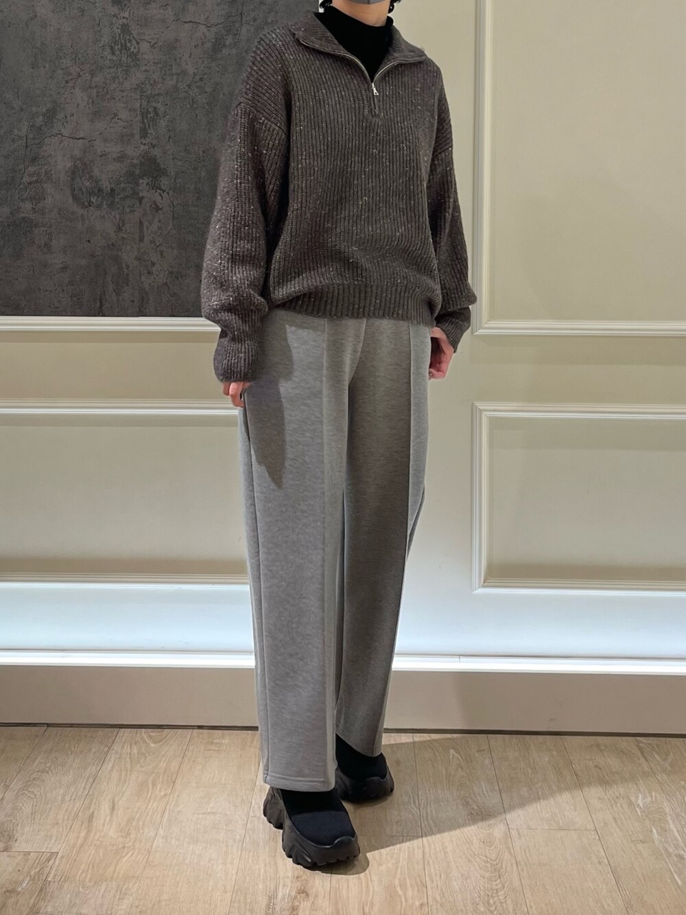 グレー系のニット/セーター、グレー系のその他パンツ、ブラック系のブーツを着用したレディースの冬コーディネートの2枚目の写真
