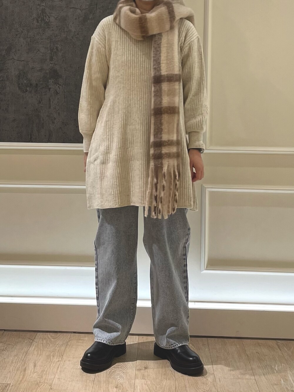ホワイト系のワンピース、ブルー系のデニムパンツ、ベージュ系のストール/ショールを着用したレディースの冬コーディネートの3枚目の写真