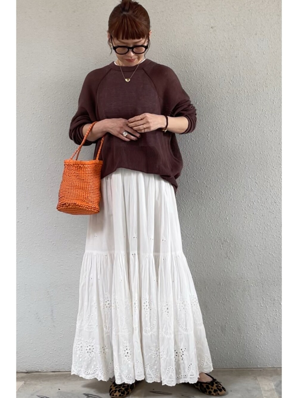 オレンジ系のトートバッグ、ホワイト系のスカート、その他のバレエシューズを着用したレディースの春コーディネートの3枚目の写真