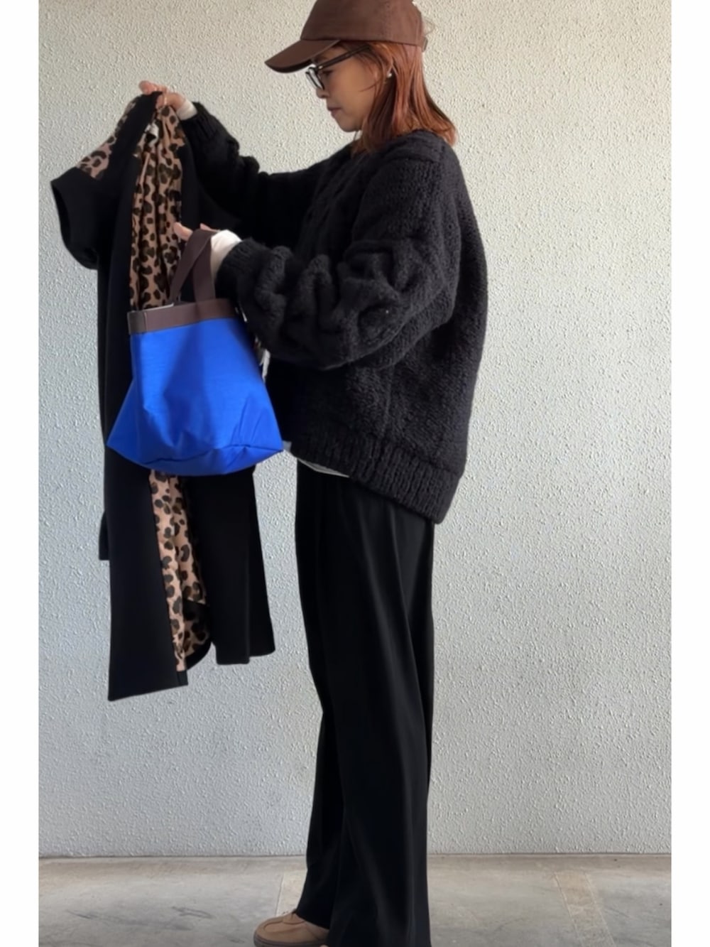 ブラック系のニット/セーター、ブラック系のその他アウター、ブラック系のスラックスを着用したレディースの冬コーディネートの2枚目の写真