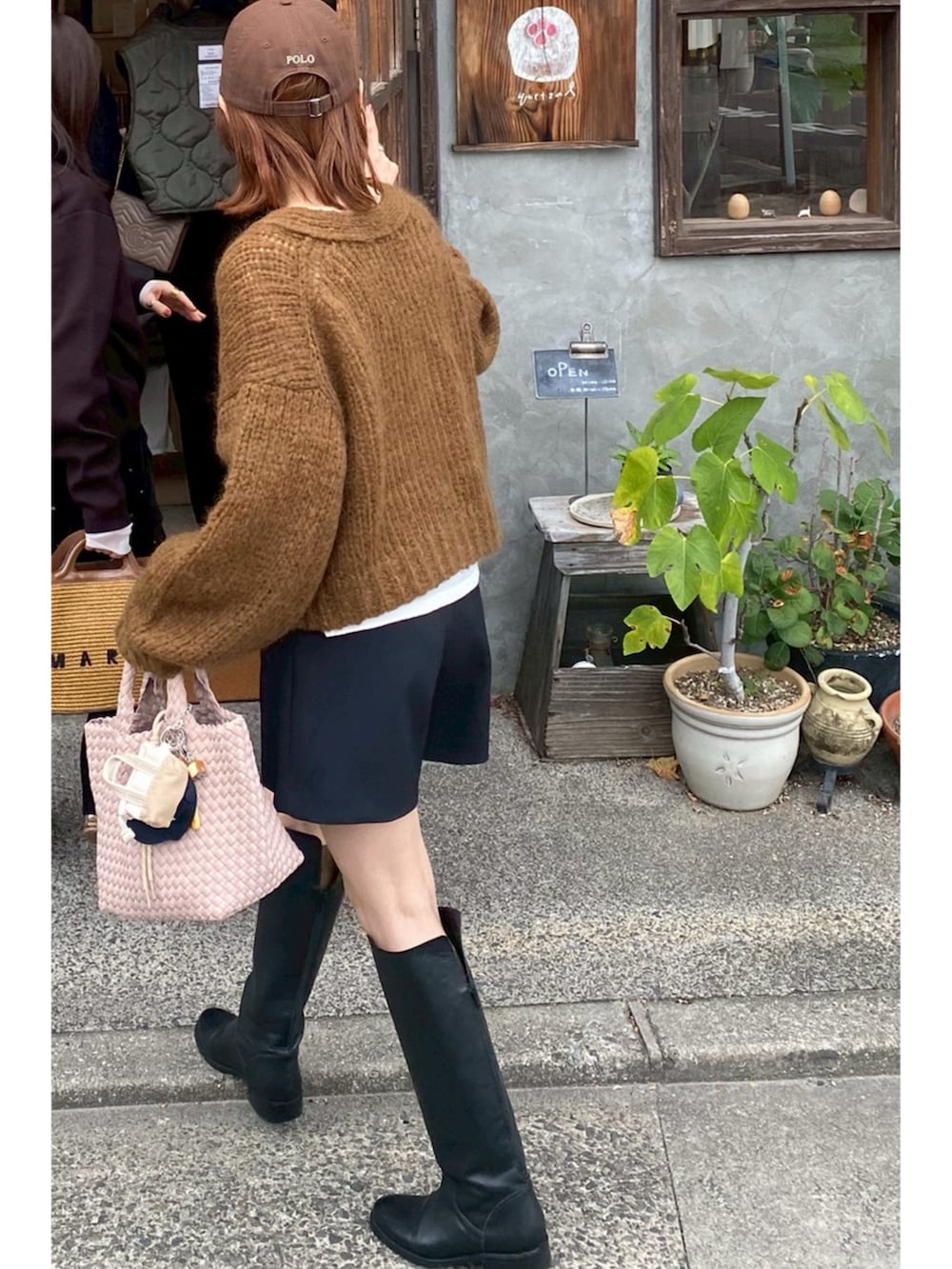 ブラウン系のカーディガン/ボレロ、ブラック系のその他パンツ、ブラック系のブーツを着用したレディースの秋コーディネートの2枚目の写真