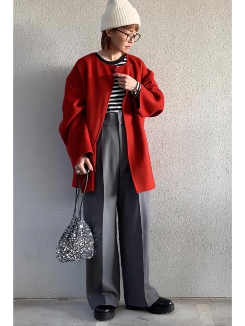 グレー系のその他パンツ、ブラック系のブーツ、シルバー系のクラッチバッグを着用したレディースの冬コーディネートの2枚目の写真