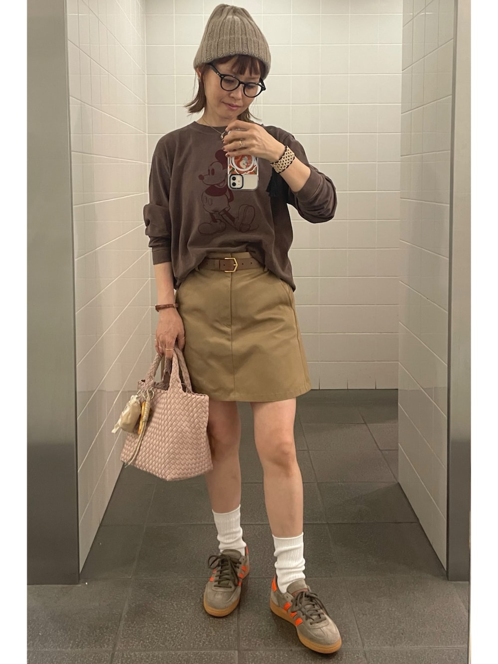 ブラウン系のTシャツ/カットソー、ベージュ系のスカート、ブラウン系のスニーカーを着用したレディースの秋コーディネートの3枚目の写真