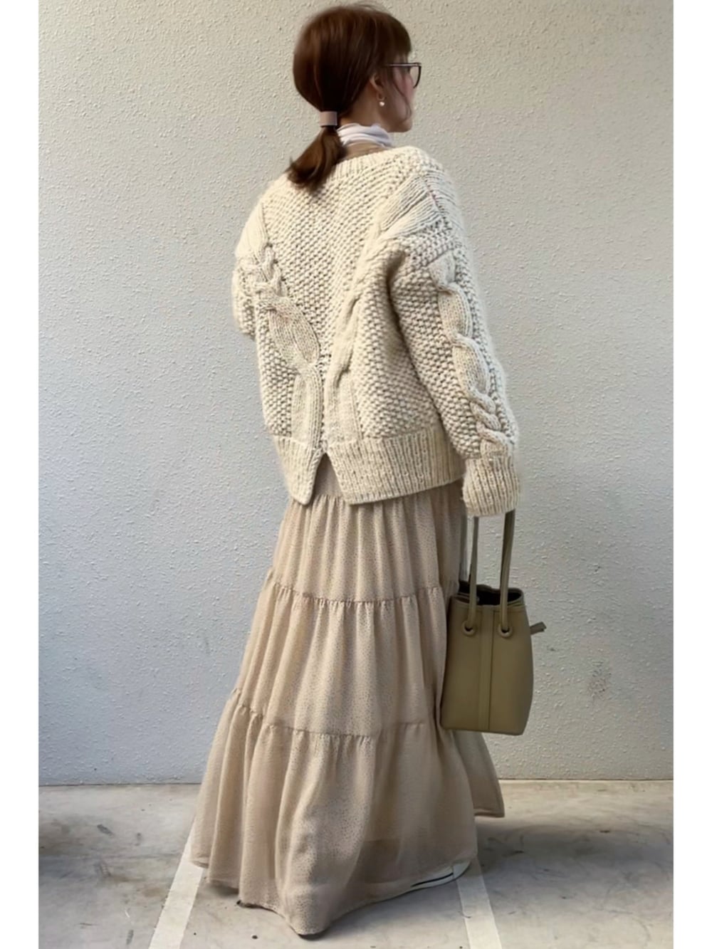 ベージュ系のカーディガン/ボレロ、グレー系のTシャツ/カットソー、ベージュ系のスカートを着用したレディースの冬コーディネートの2枚目の写真