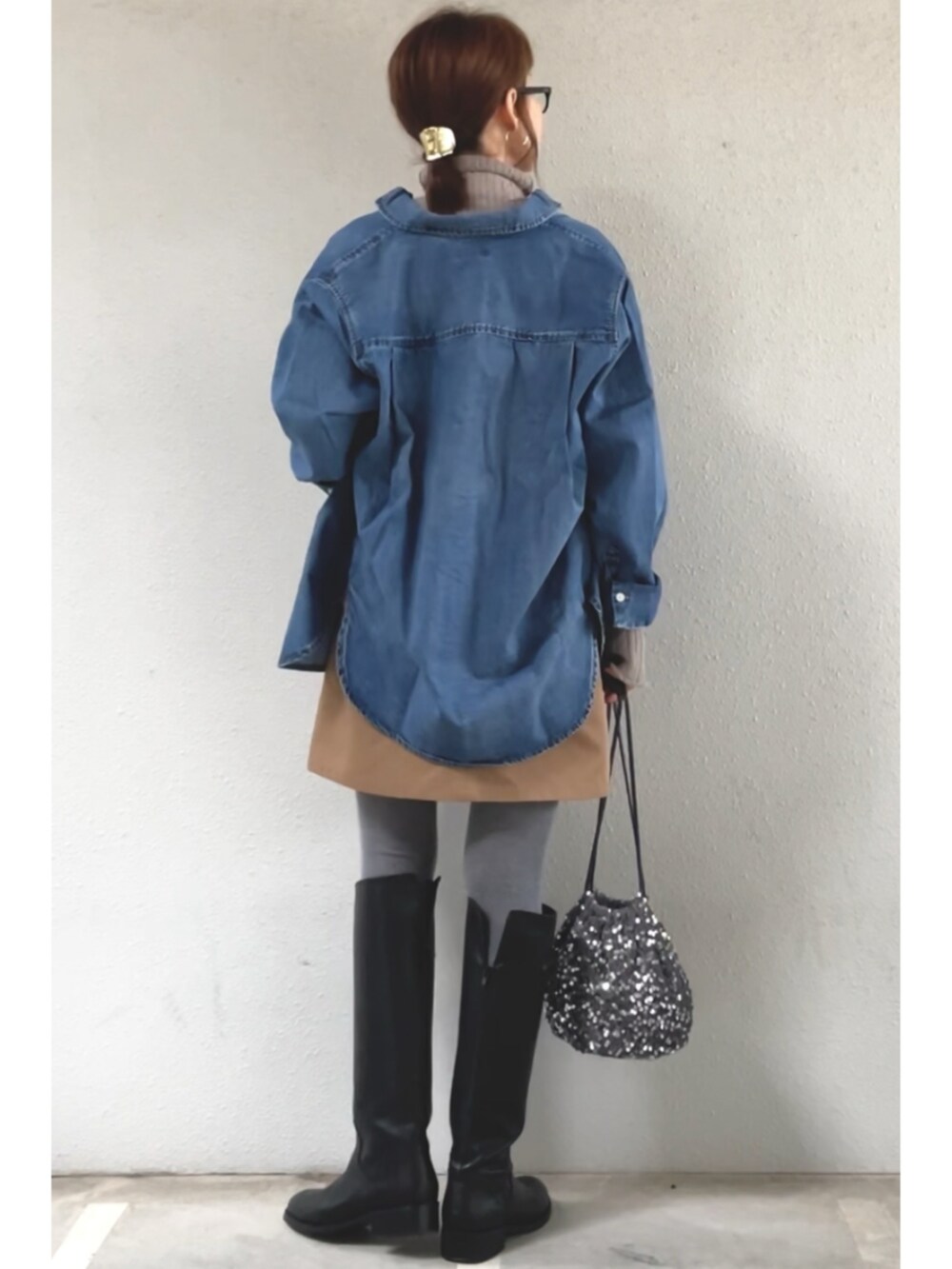 ブルー系のシャツ/ブラウス、ベージュ系のスカート、ブラック系のブーツを着用したレディースの冬コーディネートの2枚目の写真