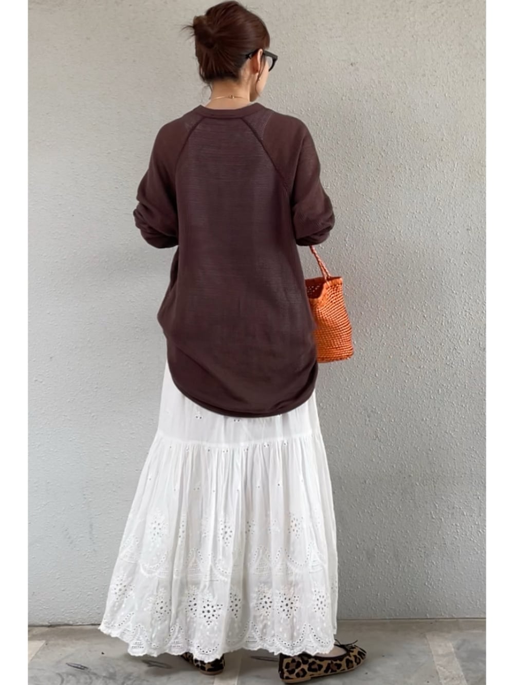 オレンジ系のトートバッグ、ホワイト系のスカート、その他のバレエシューズを着用したレディースの春コーディネートの2枚目の写真