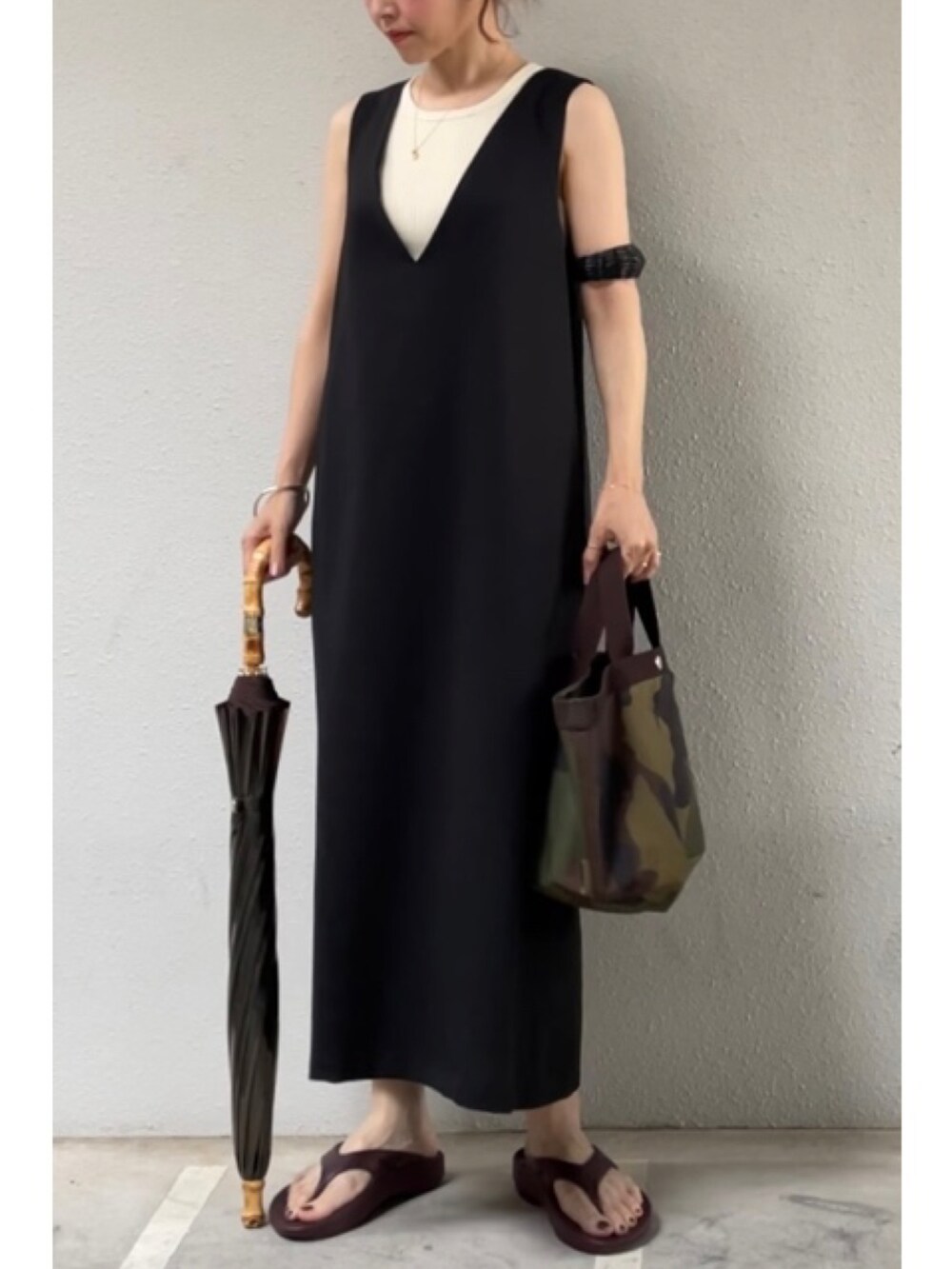 ブラック系のジャンパースカート、レッド系のサンダル、ホワイト系のその他アンダーウェア/インナーを着用したレディースの夏コーディネートの2枚目の写真