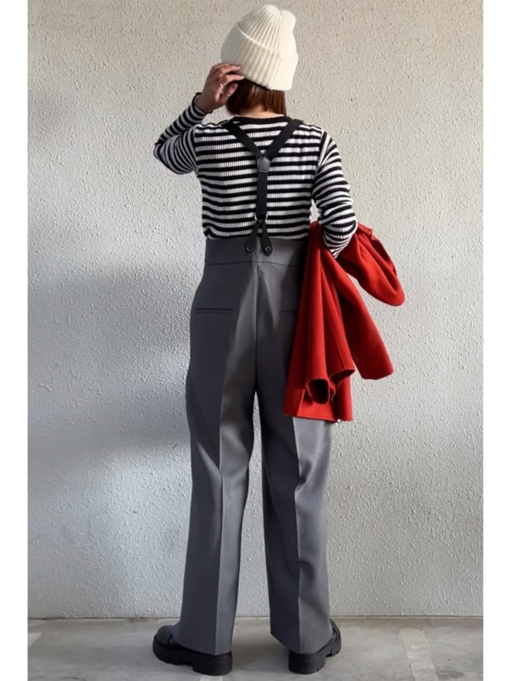 グレー系のその他パンツ、ブラック系のブーツ、シルバー系のクラッチバッグを着用したレディースの冬コーディネートの3枚目の写真