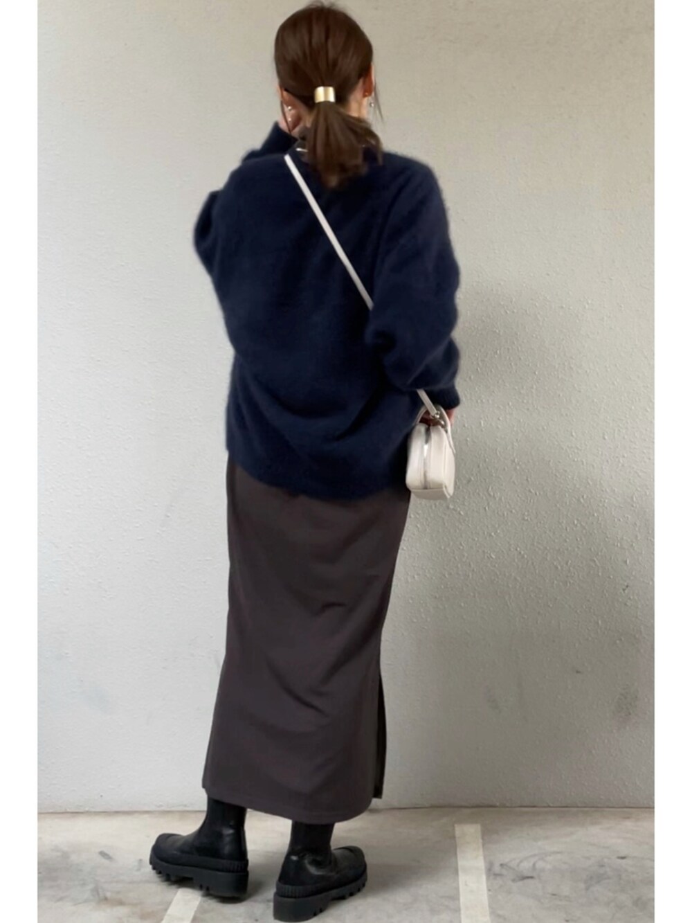 グレー系のワンピース、ホワイト系のショルダーバッグ、ブルー系のニット/セーターを着用したレディースの冬コーディネートの2枚目の写真