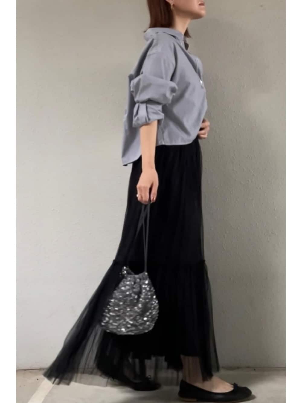グレー系のシャツ/ブラウス、ブラック系のスカート、シルバー系のクラッチバッグを着用したレディースの夏コーディネートの2枚目の写真