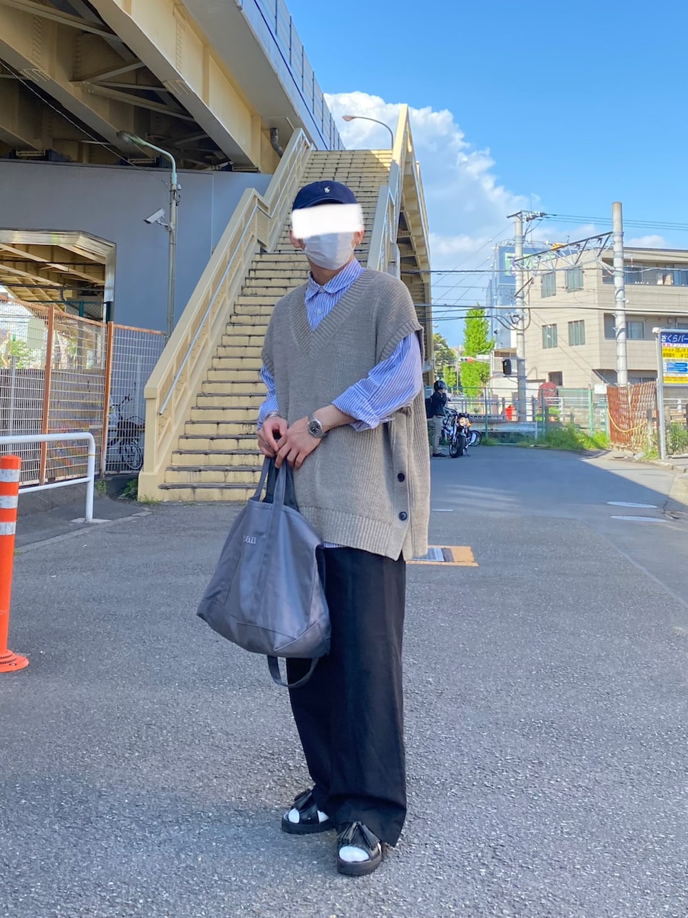 ベージュ系のベスト、ブルー系のシャツ/ブラウス、ブラック系のパンツを着用したメンズの春コーディネートの3枚目の写真