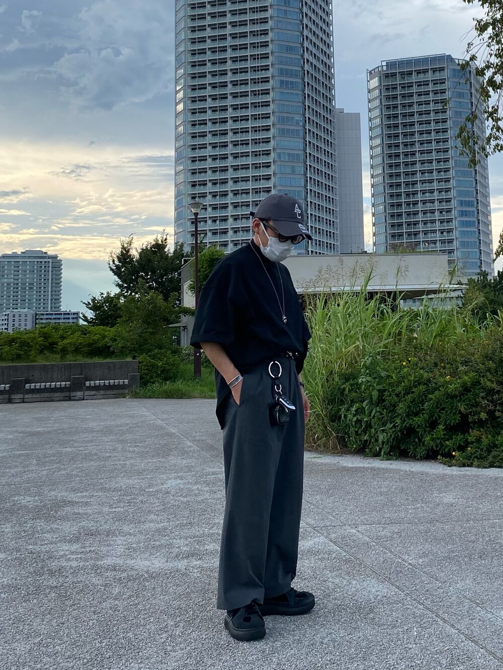 ブラック系のTシャツ/カットソー、グレー系のパンツ、ブラック系のスニーカーを着用したメンズの夏コーディネートの5枚目の写真