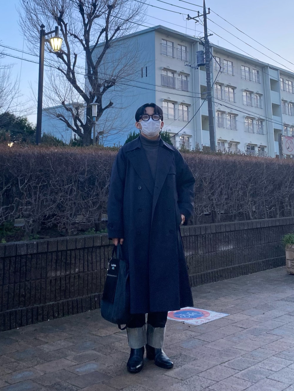 ブラック系のスウェット、ブルー系のデニムパンツ、ブラック系のブーツを着用したメンズの春コーディネートの2枚目の写真