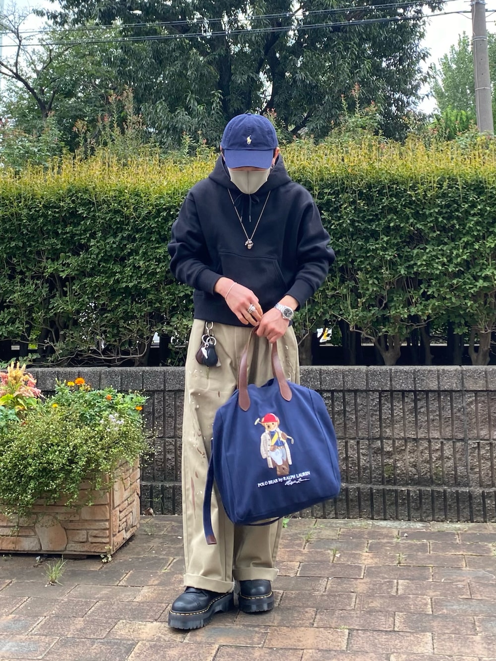 ベージュ系のチノパンツ、ブラック系のブーツ、ブルー系のトートバッグを着用したメンズの秋コーディネートの3枚目の写真