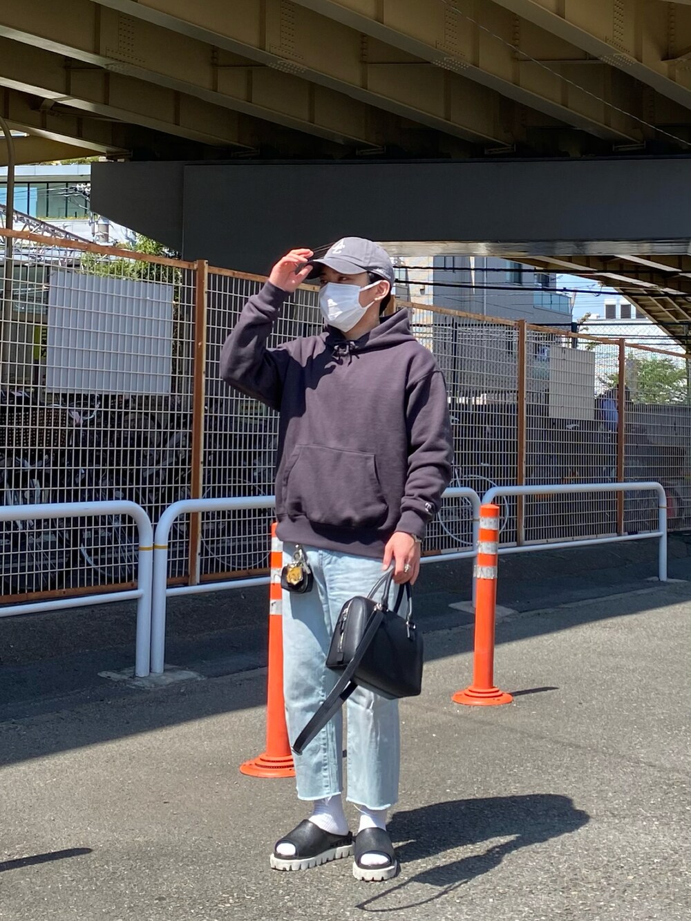 グレー系のパーカー、ブルー系のデニムパンツ、ブラック系のサンダルを着用したメンズの春コーディネートの4枚目の写真