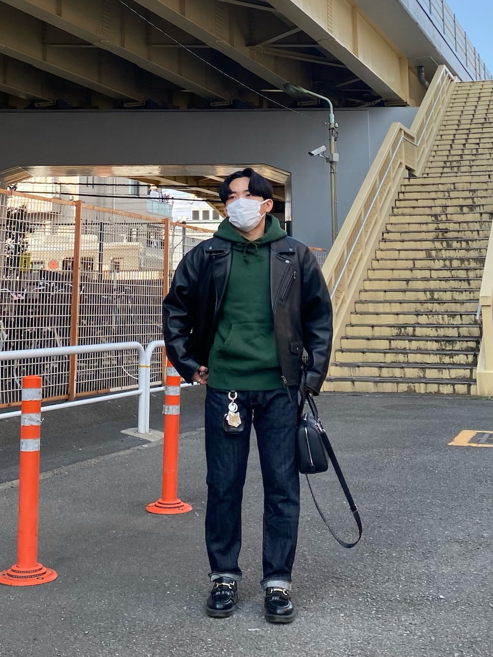 ブラック系のライダースジャケット、グリーン系のパーカー、ブルー系のデニムパンツを着用したメンズの春コーディネートの3枚目の写真