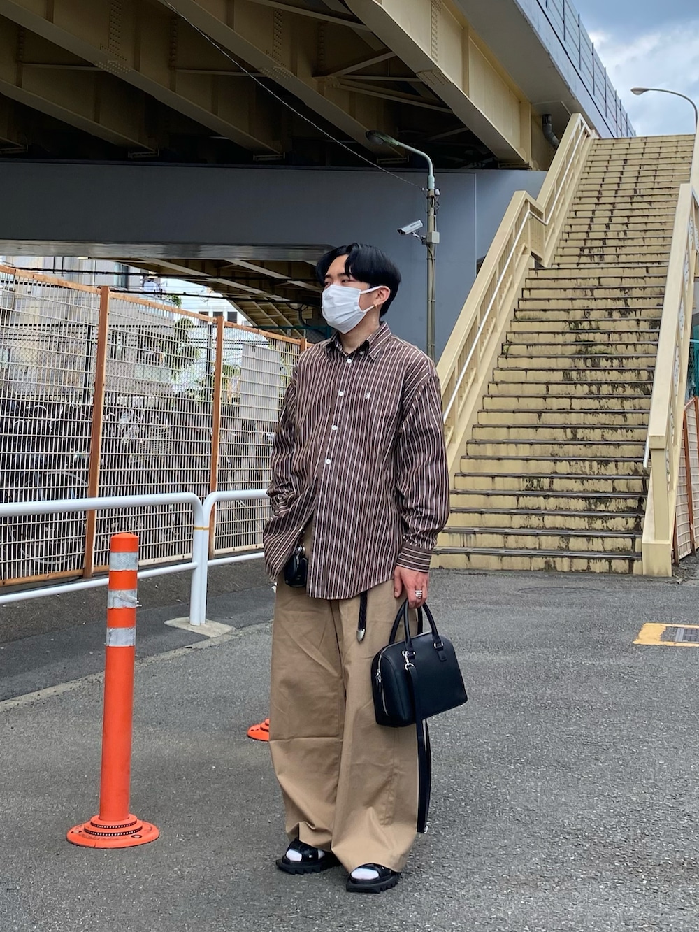 ブラウン系のシャツ/ブラウス、ベージュ系のチノパンツ、ブラック系のボストンバッグを着用したメンズの夏コーディネートの3枚目の写真