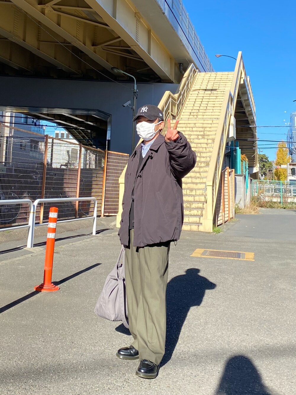 ブラック系のダウンジャケット/コート、ブラック系のベスト、ブルー系のシャツ/ブラウスを着用したメンズの冬コーディネートの5枚目の写真