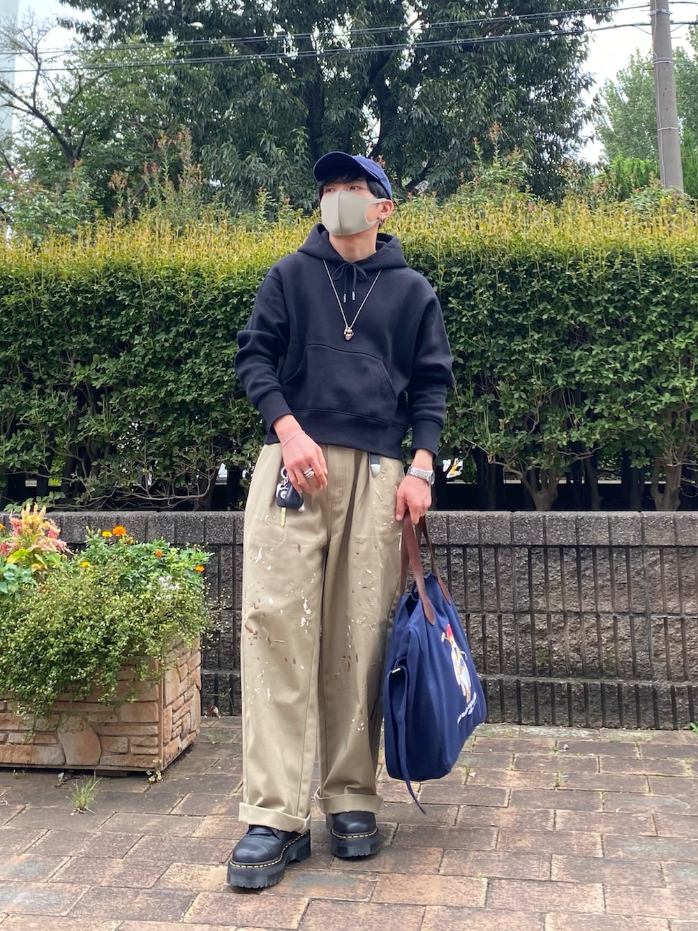 ベージュ系のチノパンツ、ブラック系のブーツ、ブルー系のトートバッグを着用したメンズの秋コーディネートの4枚目の写真