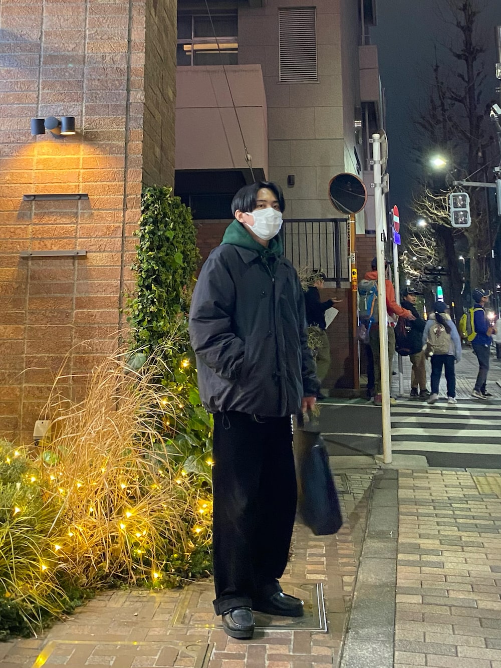 ブラック系のダウンジャケット/コート、グリーン系のパーカー、ブラック系のその他パンツを着用したメンズの冬コーディネートの4枚目の写真