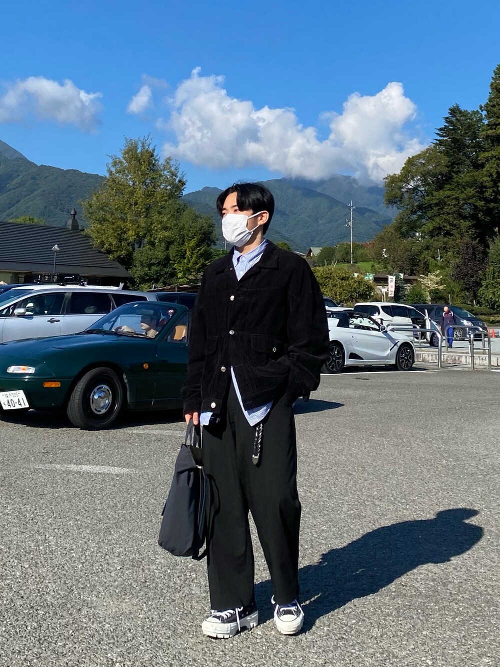 ブラック系のブルゾン、ブルー系のシャツ/ブラウス、ブラック系のパンツを着用したメンズの秋コーディネートの2枚目の写真