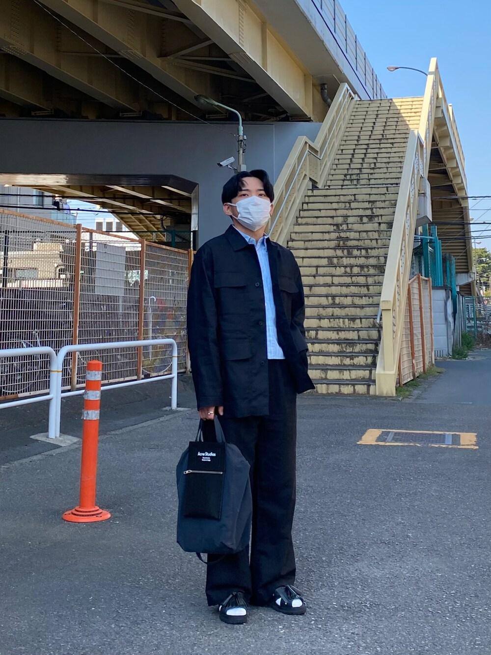 ブラック系のジャケット/アウター、ブルー系のシャツ/ブラウス、ブラック系のトートバッグを着用したメンズの春コーディネートの3枚目の写真