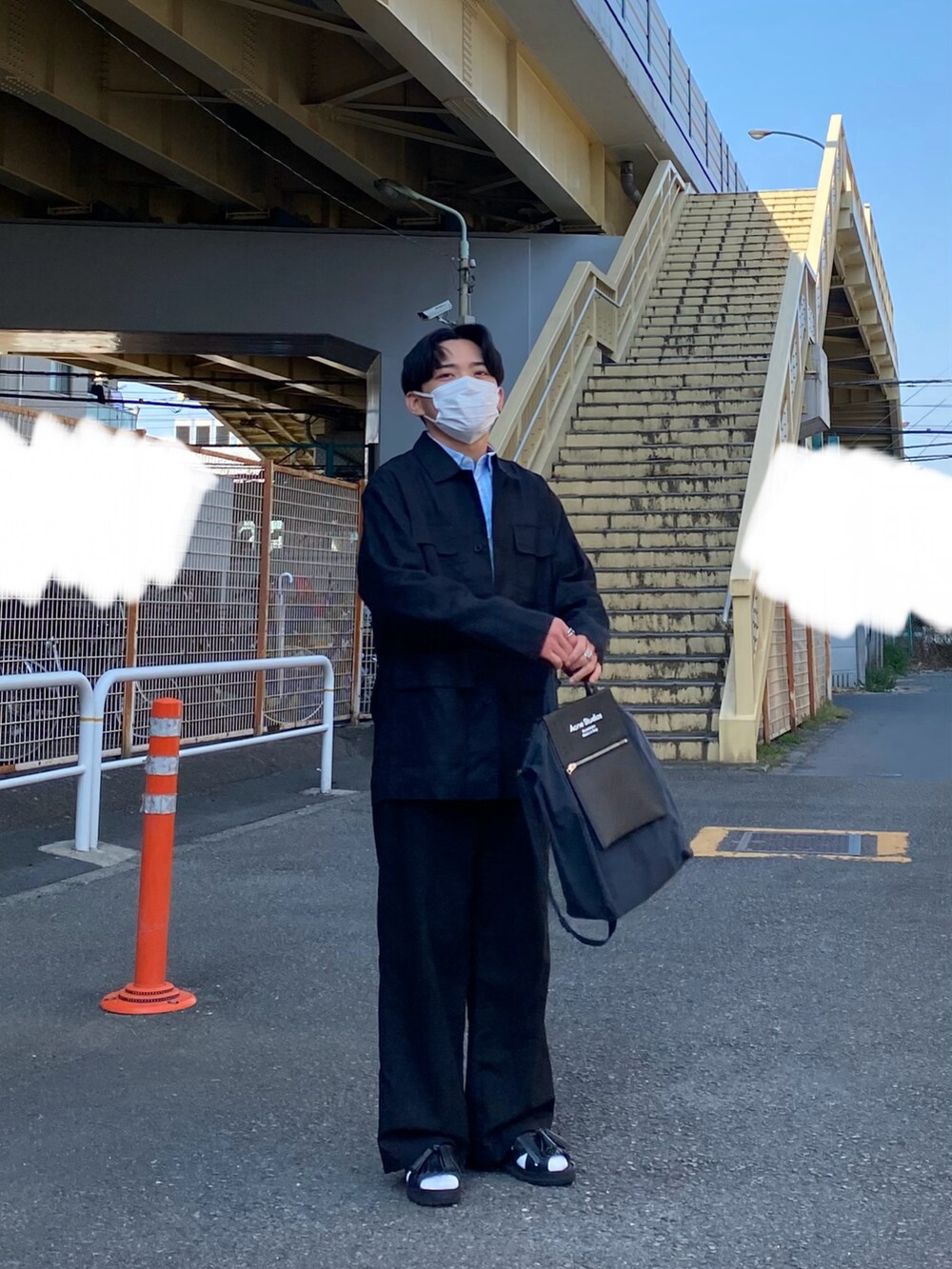 ブラック系のジャケット/アウター、ブルー系のシャツ/ブラウス、ブラック系のトートバッグを着用したメンズの春コーディネートの2枚目の写真