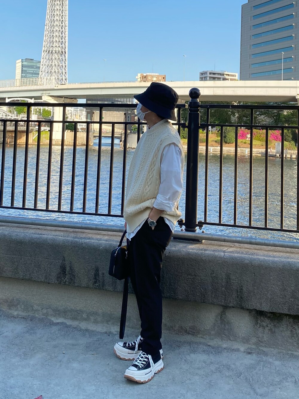 ベージュ系のニット/セーター、ホワイト系のシャツ/ブラウス、ブラック系のスラックスを着用したメンズの春コーディネートの4枚目の写真