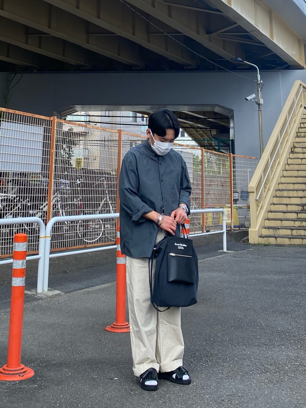 グリーン系のシャツ/ブラウス、ブラック系のトートバッグ、ホワイト系のチノパンツを着用したメンズの夏コーディネートの3枚目の写真