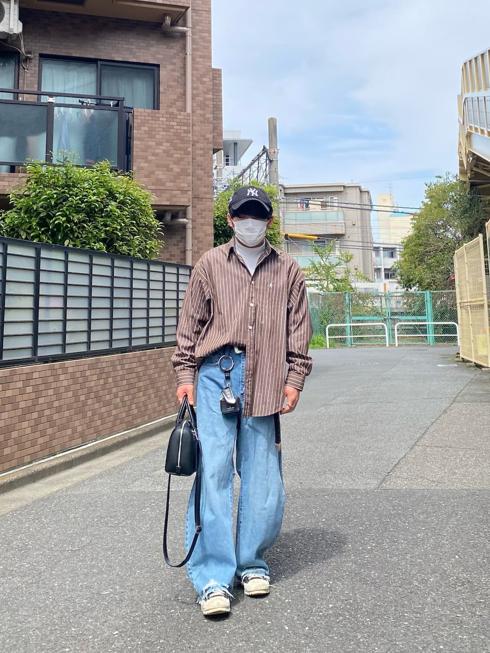 ブラウン系のシャツ/ブラウス、ホワイト系のTシャツ/カットソー、ブルー系のデニムパンツを着用したメンズの春コーディネートの4枚目の写真