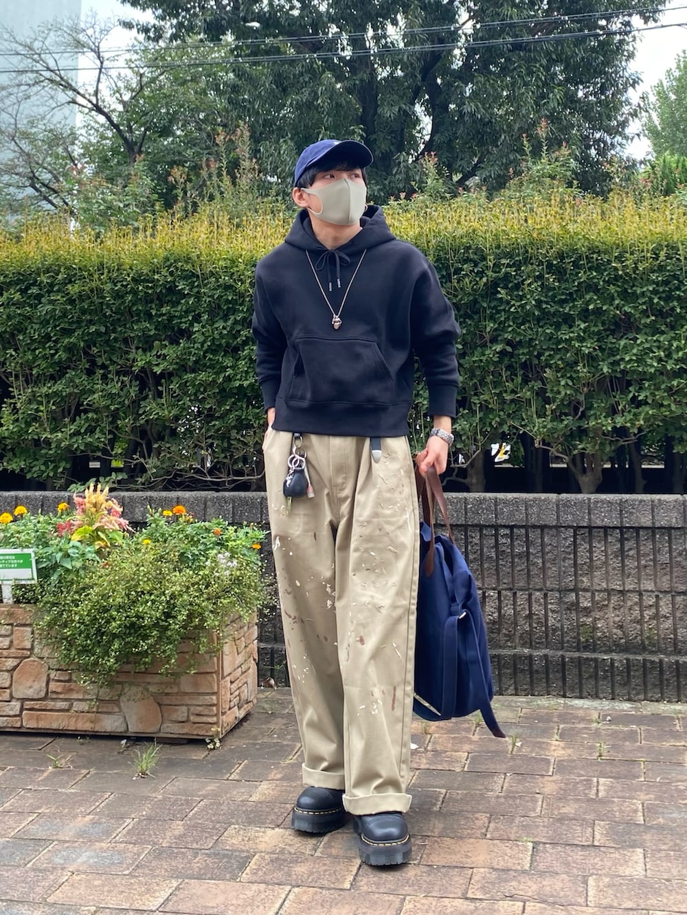 ベージュ系のチノパンツ、ブラック系のブーツ、ブルー系のトートバッグを着用したメンズの秋コーディネートの5枚目の写真